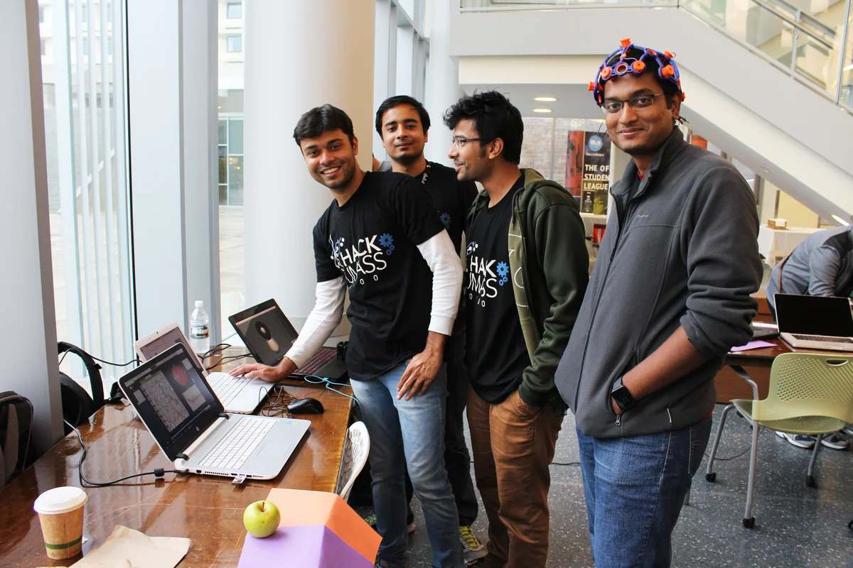HackUMass participants sharing their projects beside their laptops